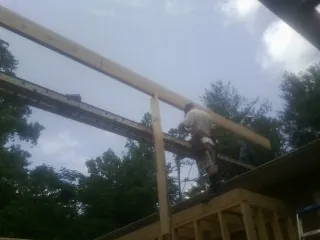 Carpenter setting a ridge beam over a new addition frame — Ice Dam Removal by Roofing Brothers in Whiteville