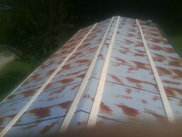 Rusted metal roof panels with new wood purlins before replacement — Storm Damage Roof Repair in Whiteville by Roofing Brothers