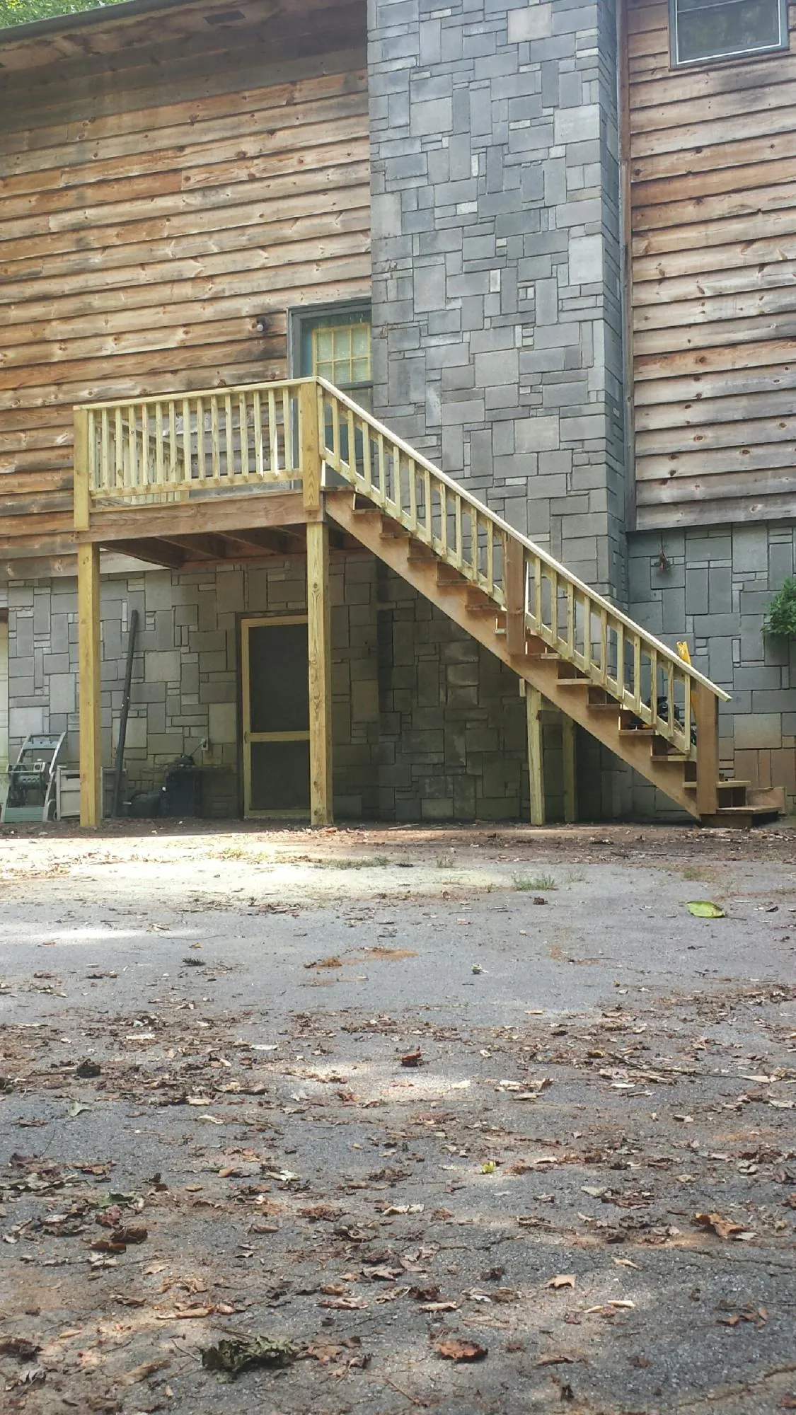 New pressure treated deck and stair landing on a log home in Whiteville