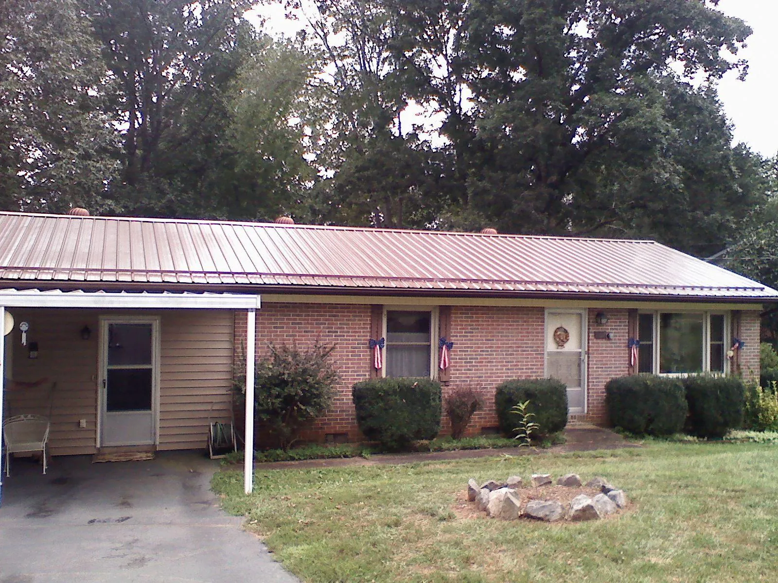 Bronze metal roof and carport on a brick ranch home — Roof Repair work by our crew in Whiteville