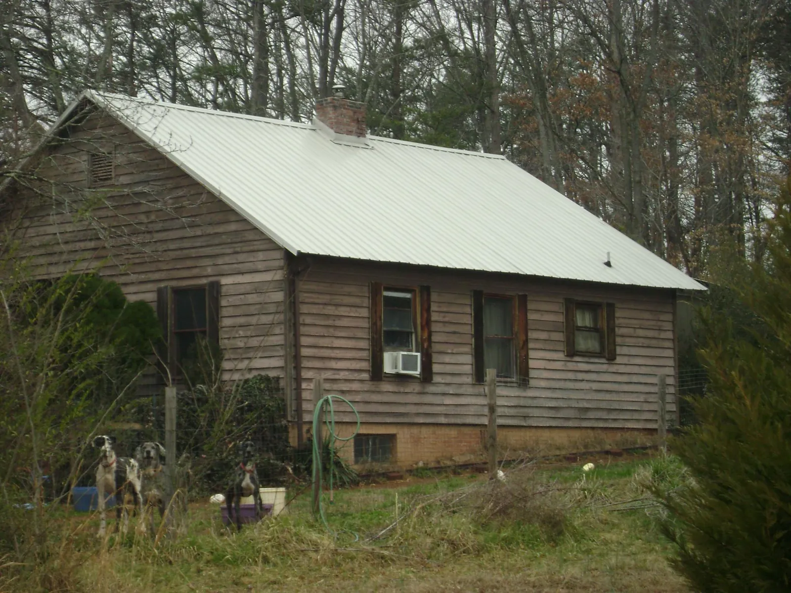 White metal roof on an old wood sided farmhouse, from a Metal Roof Installation job in Whiteville